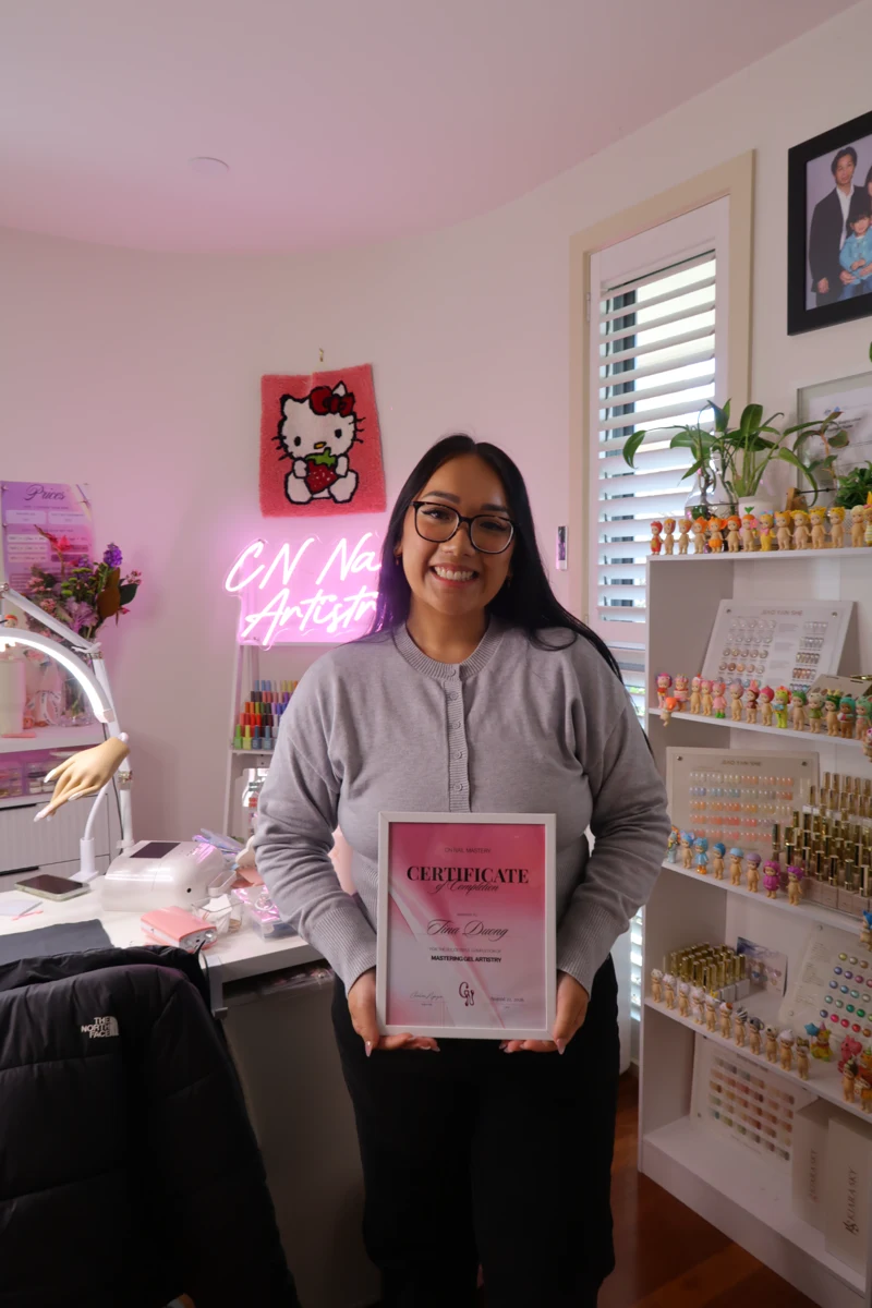 Course graduate smiling with her CN Nail Mastery certificate
