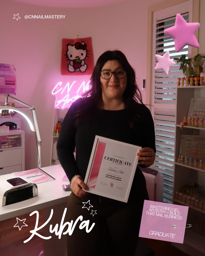 Kubra holding her CN Nail Mastery graduation certificate